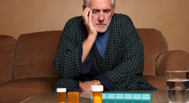 elderly man looking at his prescription bottles